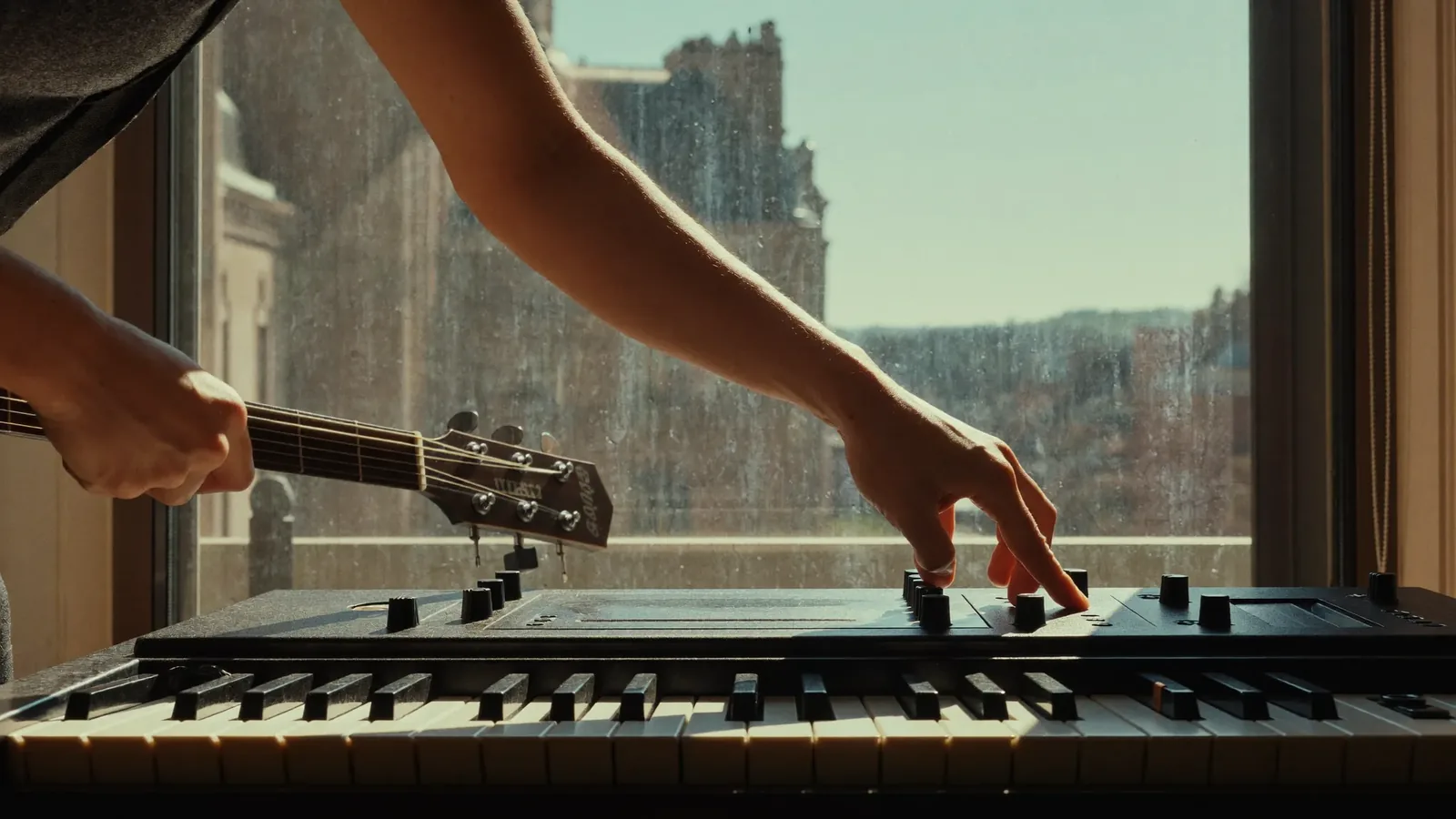 Hands pressing a new acoustic gasket into the groove around an opened window sash