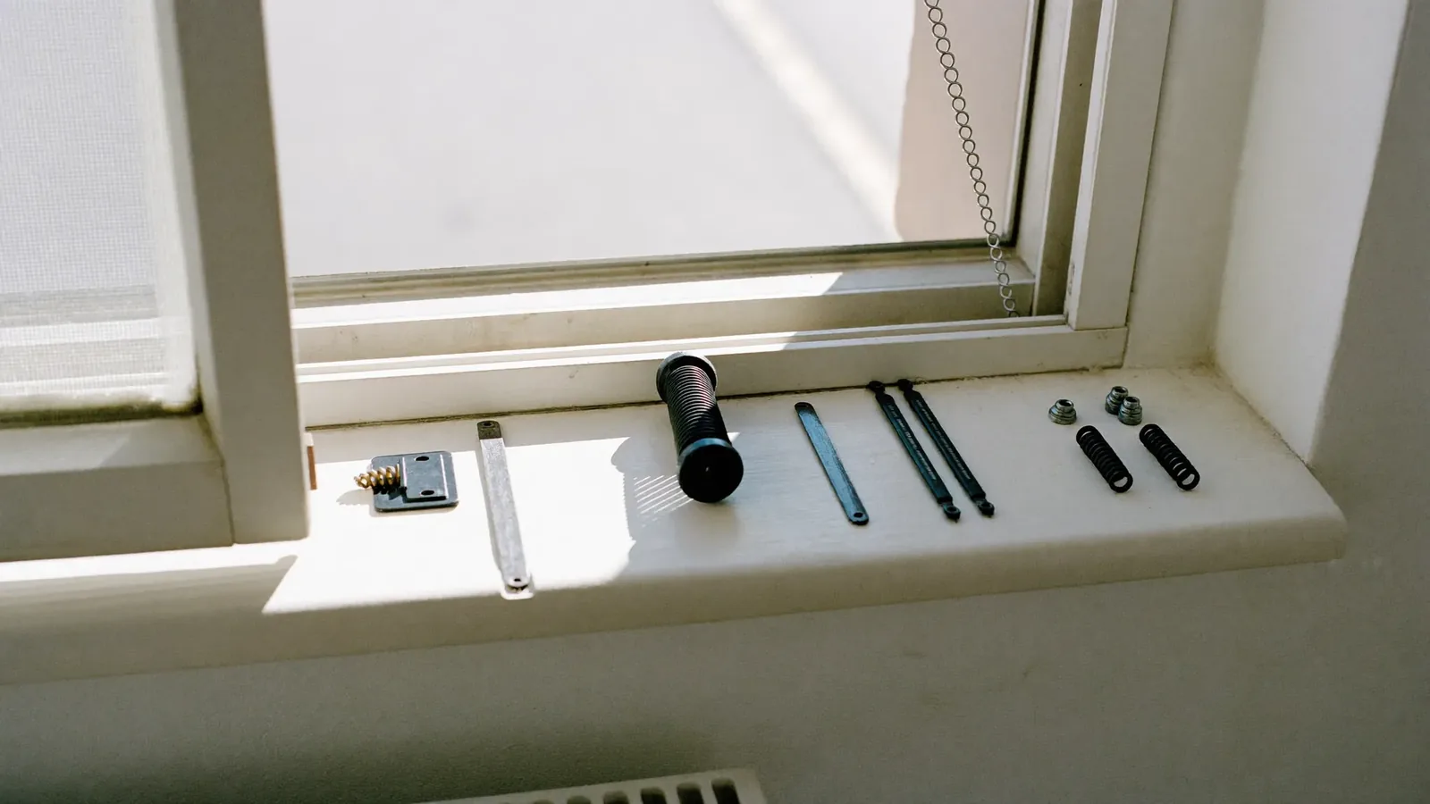 An open case of window spare parts: rollers, handles, lock strips, keeps and coils of gasket
