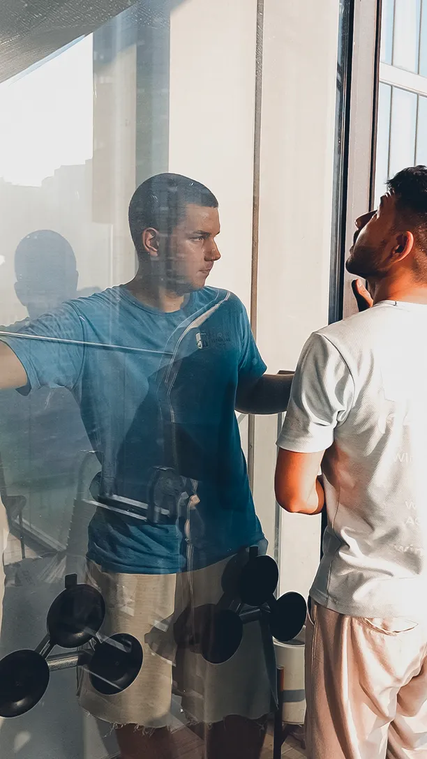 Two technicians checking panoramic glazing from inside a Dubai flat