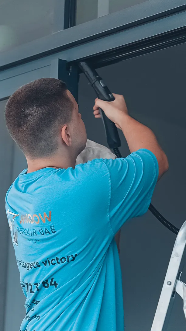Technician clearing a sliding door track before adjusting the rollers
