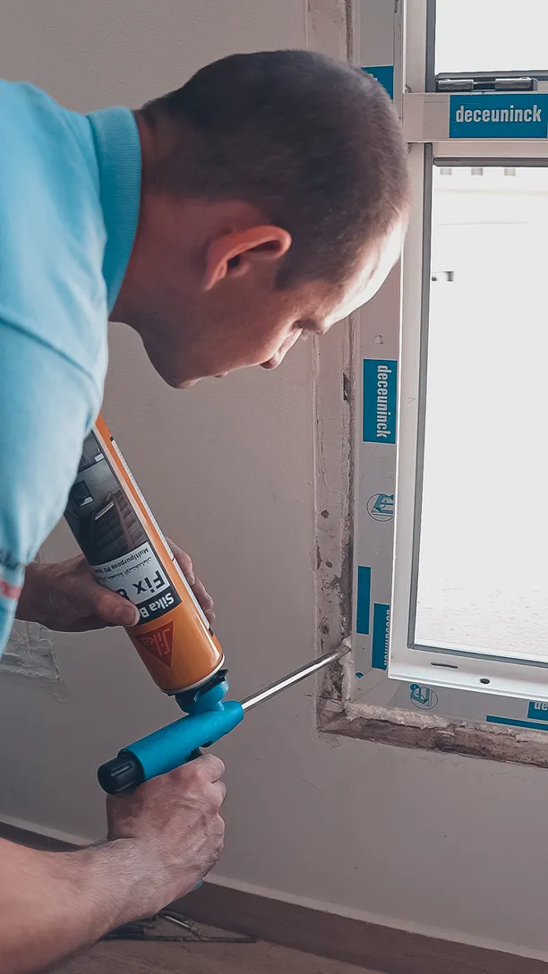 Technician applying sealant around a newly fitted uPVC window in Dubai