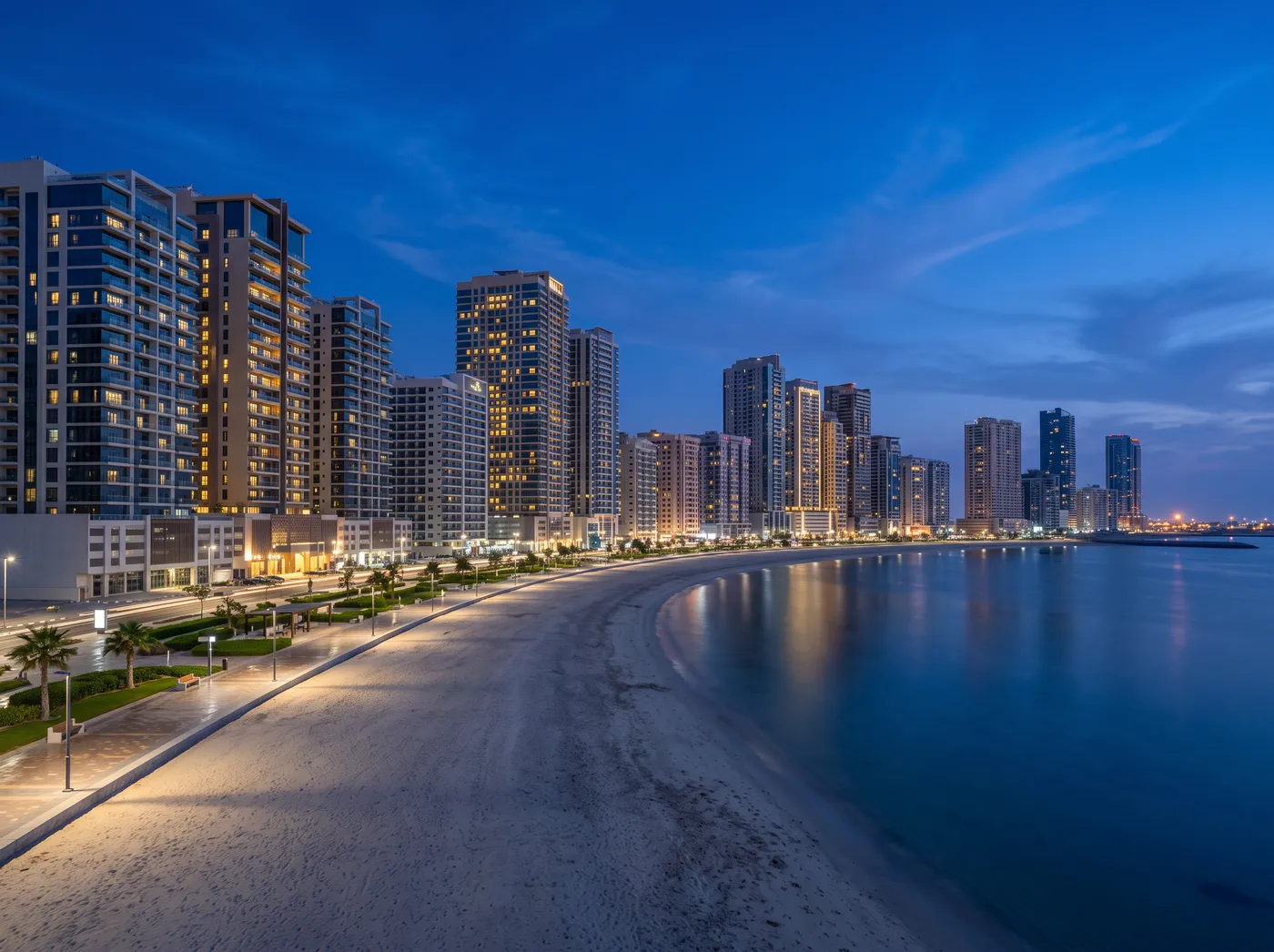 Ajman corniche towers along the shore at blue hour