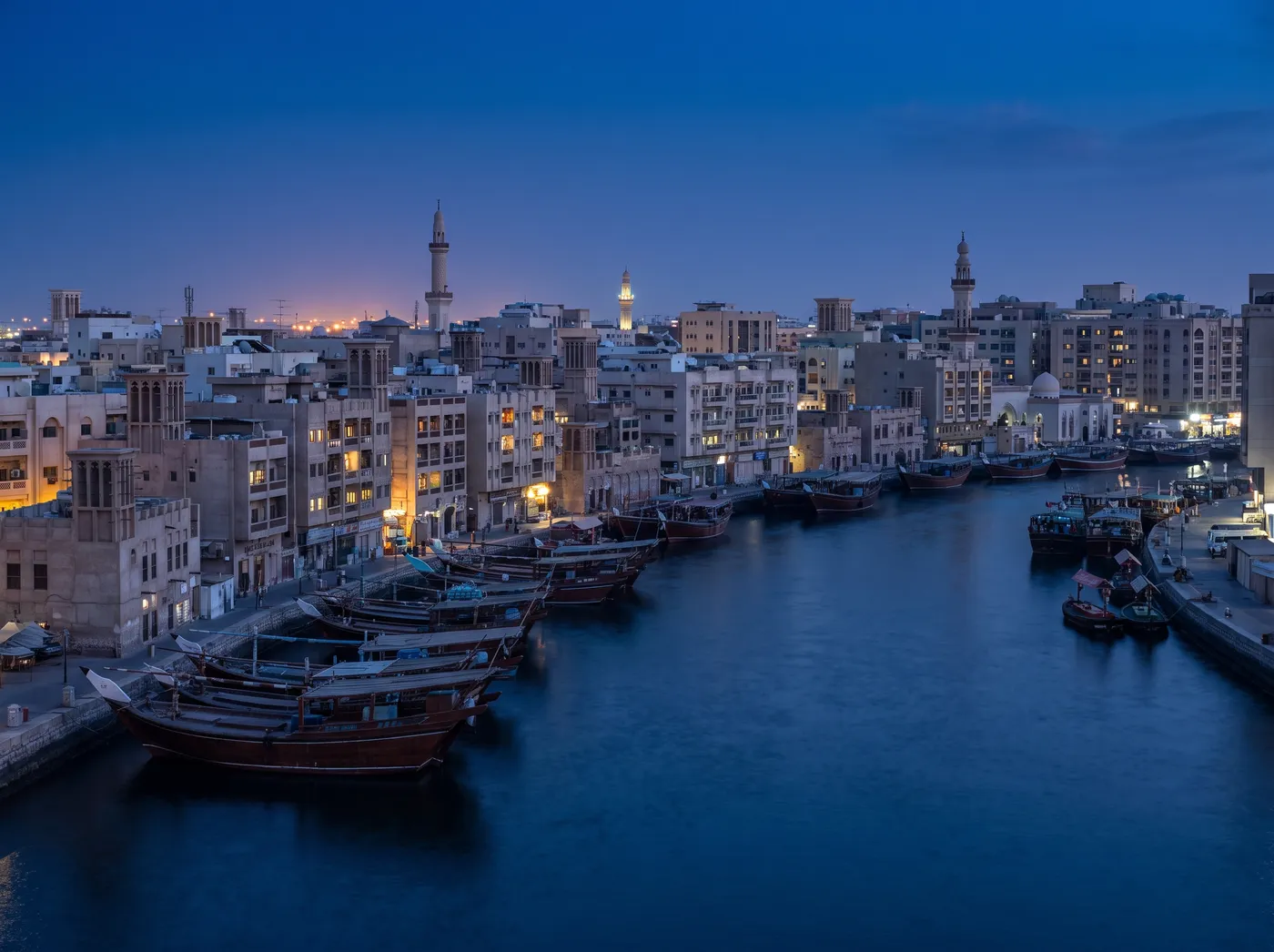 Deira blocks along the Dubai Creek at blue hour with dhows on the water