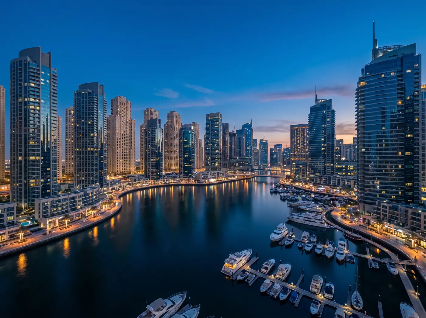 Dubai Marina towers around the marina basin at blue hour, yachts on the water