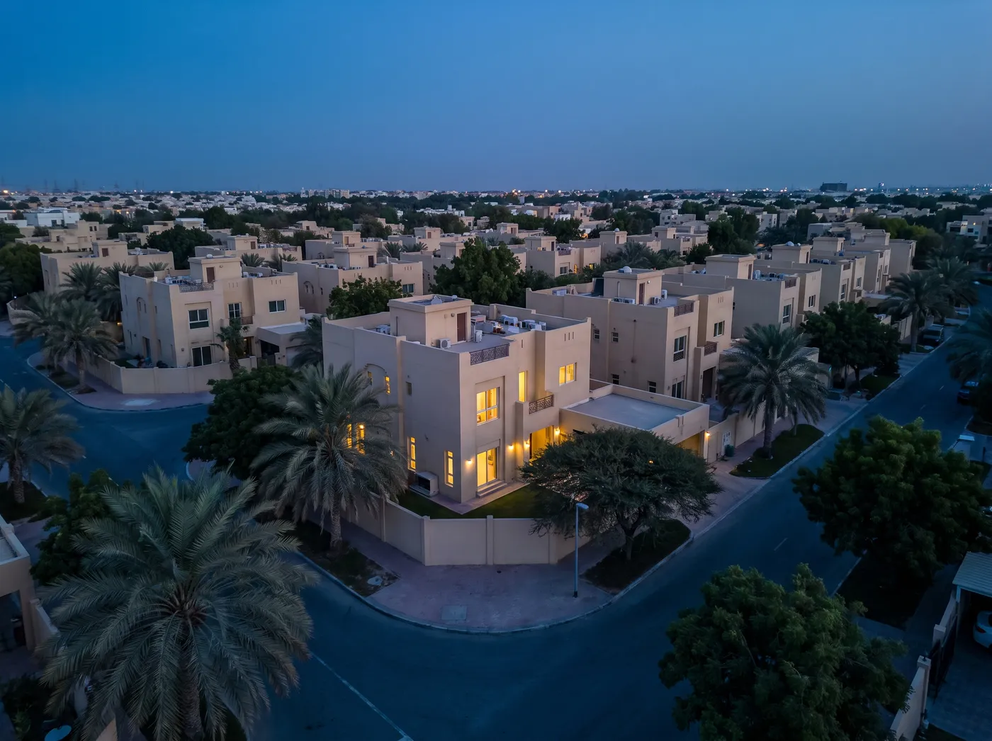 Mirdif villa neighbourhood at dusk: family villas, courtyards and mature trees