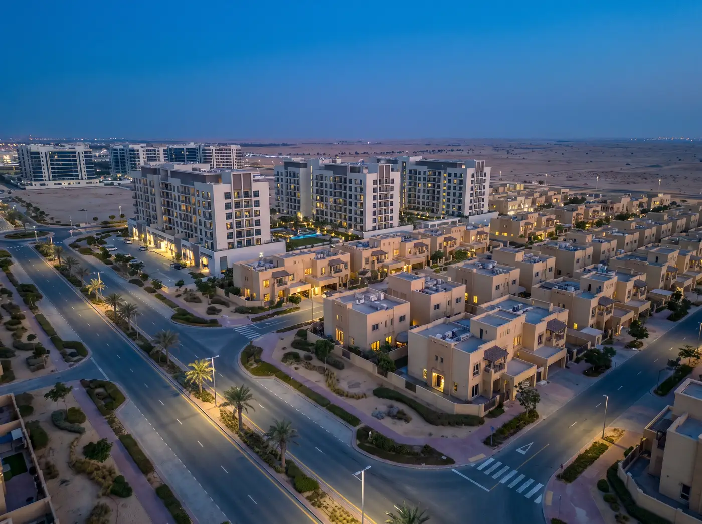 Dubai Silicon Oasis at dusk: mid-rise apartments and villa rows with open desert beyond