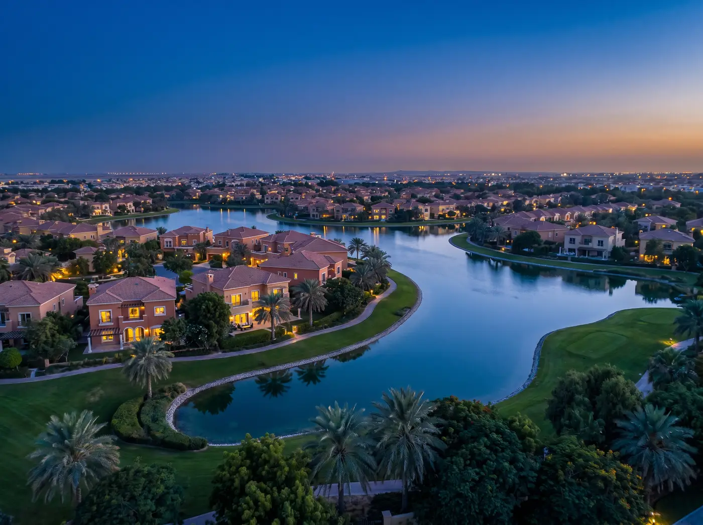 The Springs and Meadows villas around a calm lake at dusk