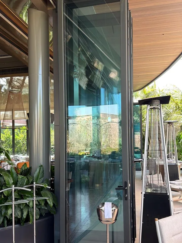 Folding glass doors onto a landscaped terrace serviced by Window Repair UAE