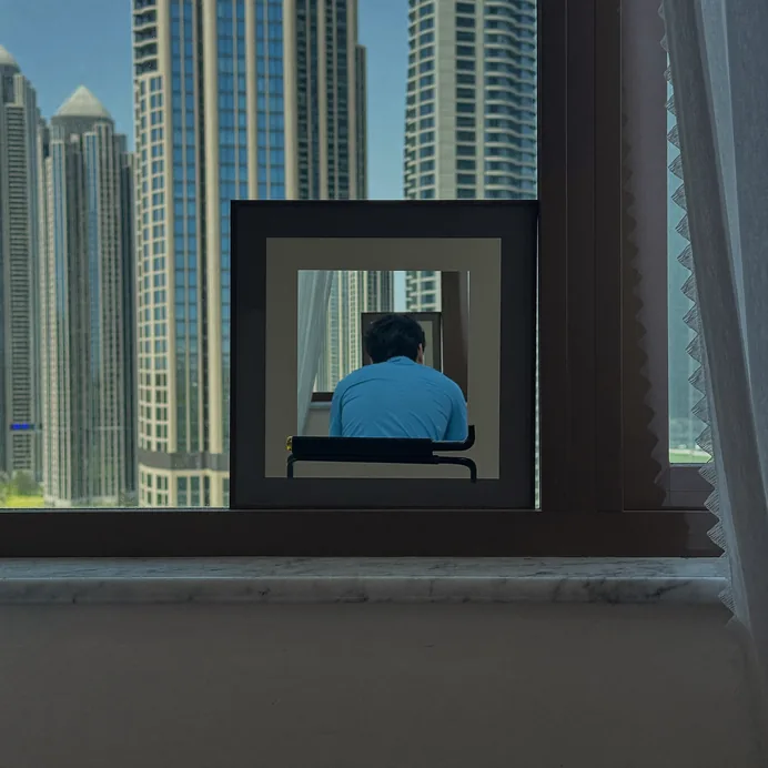 Slim framed pane on a window sill with Dubai high-rise towers outside