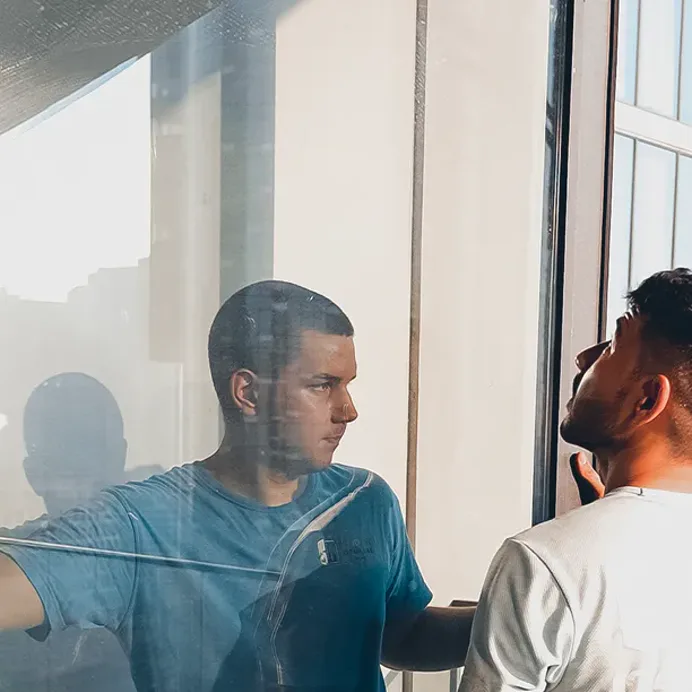 Two technicians inspecting a panoramic pane from inside